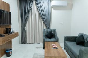 a living room with a couch and a coffee table at واحة الضيافة للشقق الفندقية Wahat Aldiyafah Hotel Apartments in Buraydah