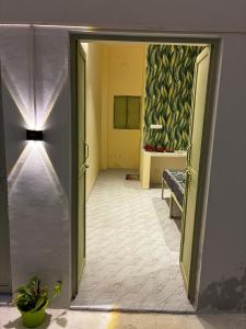 un pasillo con una puerta que da a una habitación con sofá en Prakriti wellness stay, en Haridwar 3 fotos más