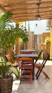 Una mesa y sillas de madera en un patio. en Pousada Bem Baia - Caraíva, en Caraíva