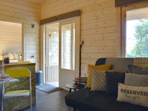 a living room with a couch and a table at Poppy Lodge in Minster