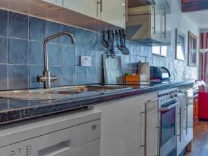 a kitchen with blue tiled walls and a sink at Seaview Retreat in Appledore +15 photos