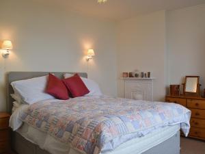 LlanaberにあるRhosmairの赤い枕が置かれたベッドのある寝室