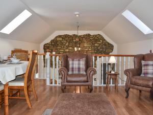 sala de estar con mesa, 2 sillas, mesa y sillón en Ysgubor Blaenparc Barn - Uk41030, en Mydroilin