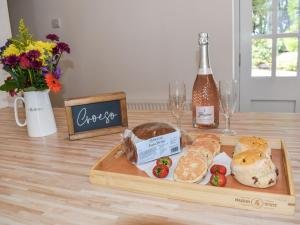 una mesa con una bandeja de pan y una botella de vino en Ysgubor Blaenparc Barn - Uk41030, en Mydroilin 10 fotos más