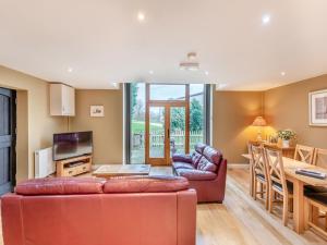 een woonkamer met een bank en een tafel bij Oak Cottage in Ware