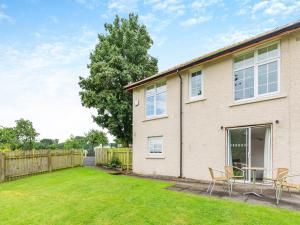 a house with chairs and a yard at Cartmel Cottage in Lindale