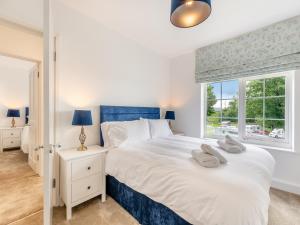 ein Schlafzimmer mit einem großen weißen Bett mit einem Fenster in der Unterkunft Cartmel Cottage in Lindale