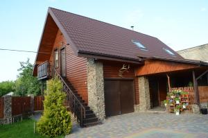 una casa con techo marrón y garaje en Agrousadba Kamenetskoye Zatishye, en Kamenets