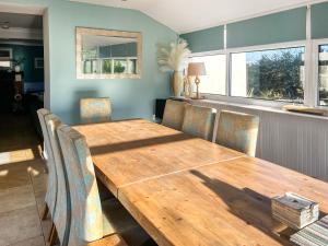 a dining room with a wooden table and chairs at Goleufryn in Abersoch