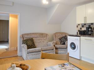ein Wohnzimmer mit zwei Stühlen und einer Waschmaschine in der Unterkunft Paddock Cottage - Ukc3783 in West Down