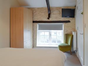 ein Schlafzimmer mit einem Bett und einem Stuhl und einem Fenster in der Unterkunft Paddock Cottage - Ukc3783 in West Down + 15 Fotos