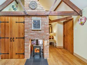 un camino in mattoni in una stanza con porta in legno di Cowslip Cottage a Swarland