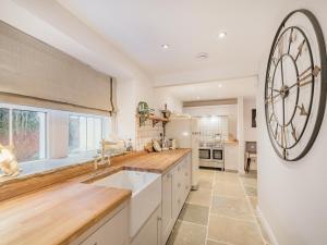 una cucina con un grande orologio sul muro di Keepers Cottage a Durisdeer