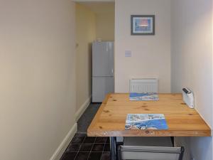 a kitchen with a wooden table and a refrigerator at Viking Bay Apartment in Broadstairs