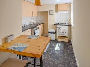 a kitchen with a wooden table and a counter top at Viking Bay Apartment in Broadstairs +7 photos