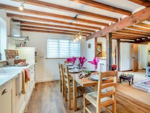 een keuken en eetkamer met een houten tafel en stoelen bij The Cottage in Arminghall