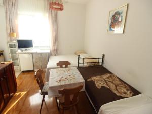 a small room with a bed and a table and a desk at Apartment in Starigrad near the Beach in Starigrad-Paklenica +17 photos