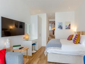 a bedroom with a bed and a table and a couch at Belgrave Sands Apartment in Torquay