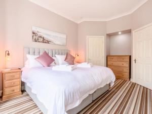a bedroom with a large white bed with pink pillows at Buoy On The Bay in Bridlington