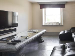 een woonkamer met een glazen tafel en een bank bij Souterstead in Torver