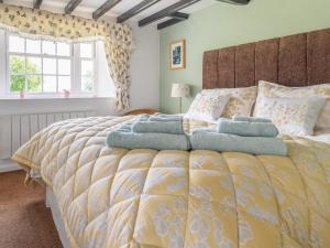 a bedroom with a large bed with pillows at Garden Cottage in Morland