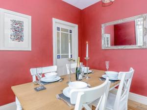 a dining room with a table and a red wall at Station House in Millers Dale