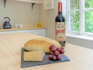 a bottle of wine and a loaf of bread and grapes at Station House in Millers Dale +16 photos