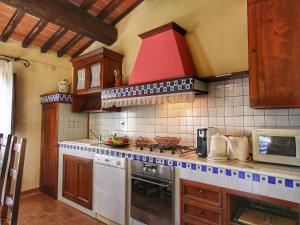 a kitchen with a stove and a red hood at Chianti Hillside Farmhouse in Radda in Chianti