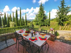 a table with chairs and plates of food on a patio at Chianti Hillside Farmhouse in Radda in Chianti