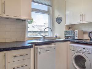 a kitchen with a sink and a washing machine at Woodys in Windermere