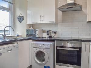 a kitchen with a washing machine and a sink at Woodys in Windermere +6 photos