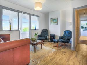 a living room with two chairs and a couch at Bellair in Marhamchurch