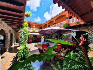 an outdoor patio with tables and umbrellas on a building at La Serrania B&B in Boquete