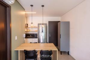 a kitchen with a wooden table and a refrigerator at Apto c/ 1 Suíte a 700 m da Praia ELR0507 in Maceió