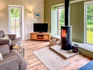 ein Wohnzimmer mit einem Holzofen in der Unterkunft Kingfisher Cottage in Kirkton of Airlie