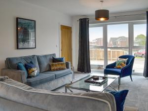 a living room with a couch and a table at West Lodge in Sewerby