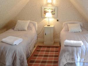 a attic bedroom with two beds and a lamp at Tressady Coach House in West Langwell
