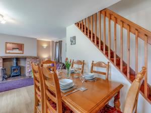 ein Esszimmer mit einem Tisch und einer Treppe in der Unterkunft The Cottage - 28645 in Alston