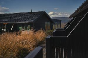 a black house with a fence in front of it at Hofsstadir - Country Hotel in Hofstaðir +13 photos