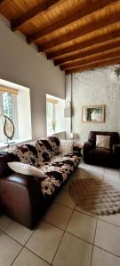 a living room with a leather couch and a table at Maison de caractère - L'évasion forestière in Baguer-Pican