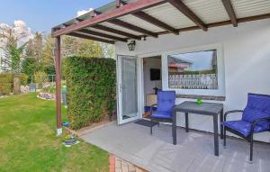 un patio avec deux chaises bleues et une table dans l'établissement Ferienhaus Waren Müritz, à Warenshof 8 autres photos