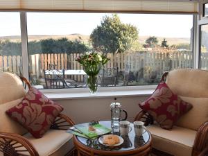 a living room with a table and chairs and a window at Thistle Cottage in Carlton