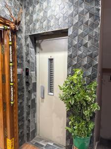 にあるVaralaxmi Nilayam Guest Houseの植物の前の扉