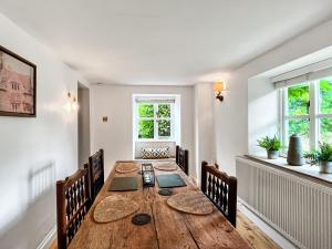 ein Esszimmer mit einem Holztisch und Stühlen in der Unterkunft Oasis Cottage in Broughton Gifford