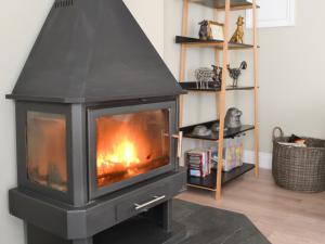 einen schwarzen Kamin im Wohnzimmer mit in der Unterkunft Red Hen Cottage in Broomhill