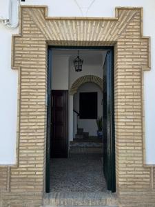 an entrance to a building with a brick wall at Apartamento andaluz en el corazón de Arahal in El Arahal