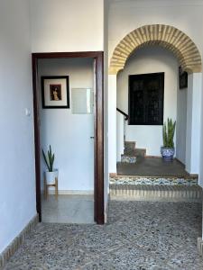 an entrance to a house with an archway and a door at Apartamento andaluz en el corazón de Arahal in El Arahal