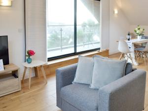 a living room with a couch and a large window at Lyndhurst in Perranporth