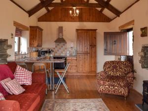 ein Wohnzimmer mit Couch und Küche in der Unterkunft Barns End Cottage in Ludchurch