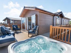 a hot tub on the deck of a house at Coastal Retreat - Uk37722 in Ingoldmells
